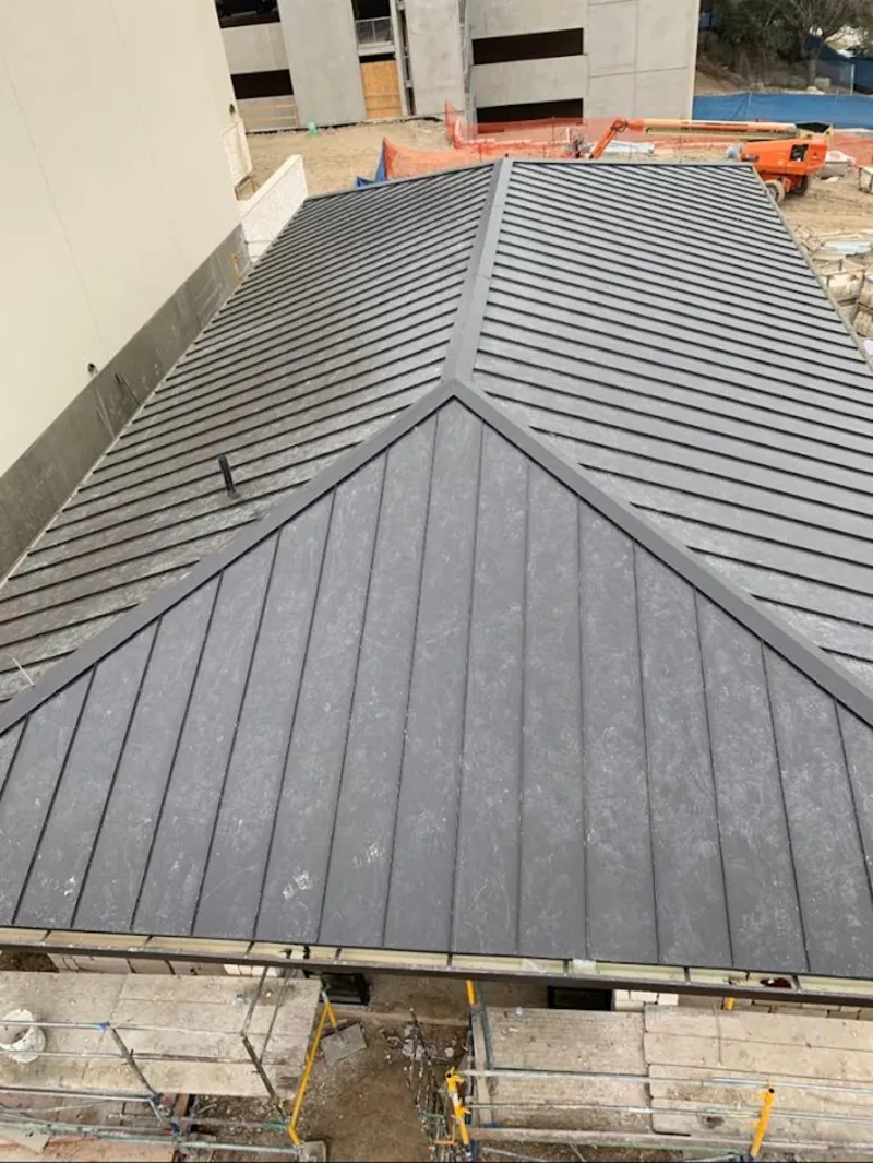 Commercial metal roof construction with crane equipment in Swampscott